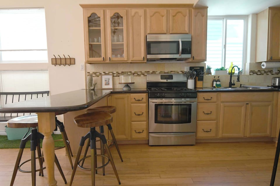 Whip up your favorite meals in this classic kitchen featuring warm wood cabinetry, stainless steel appliances, and a convenient breakfast bar with stylish swivel stools.