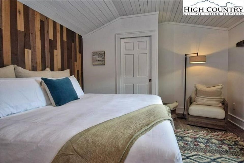 Stylish reclaimed wood feature wall behind the king bed.
