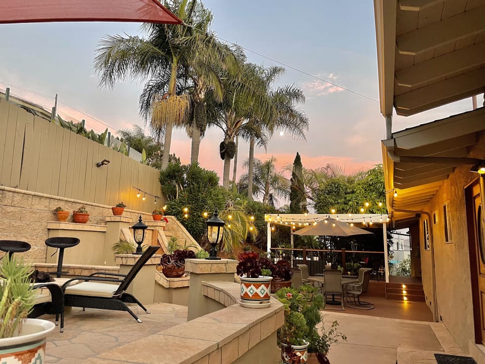 Back patio with  built in BBQ, fire pit and kitchen at sunset.