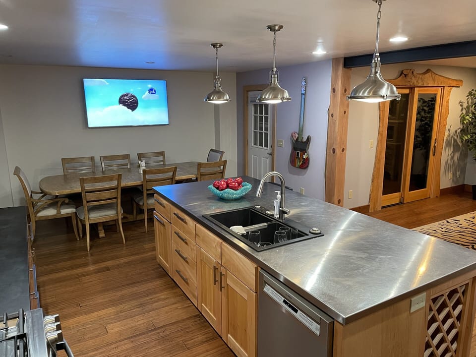 Kitchen with dining room table for eight . Includes big screen TV , bar stools 