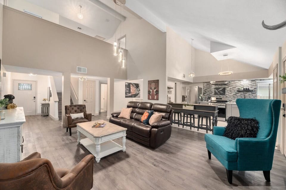 Open living space with vaulted ceilings, statement lighting, and layered seating offers a warm place to unwind, connect, and feel at home.