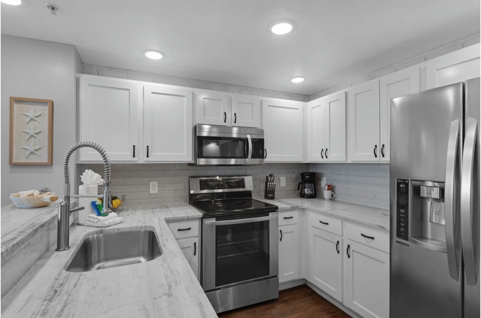 Your bright, fully-equipped kitchen awaits with stainless steel appliances, marble countertops, and all the cookware you need for memorable meals.