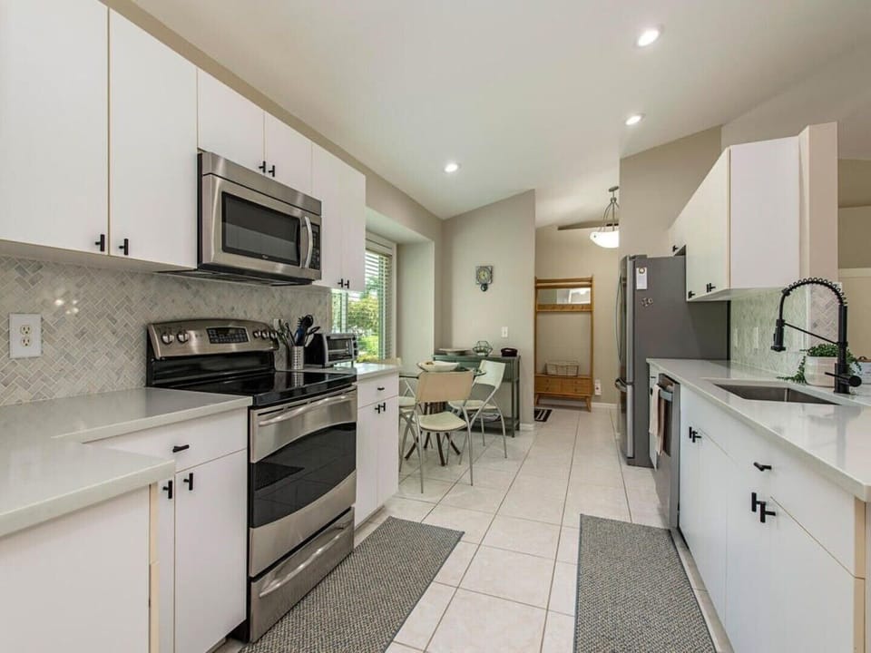 Eat in kitchen with quartz countertops and stainless steel appliances 