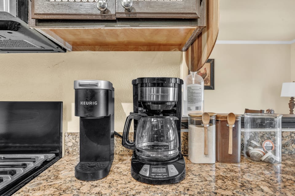 A K-cup and drip coffee maker with coffee, pods, and sugar