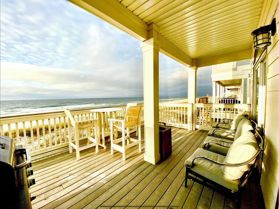Large Deck on beach with covered area with plush chairs, bar-b-que, seats 11
