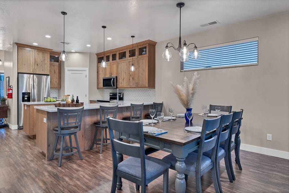 A dining area next to the kitchen includes a large table and chairs.