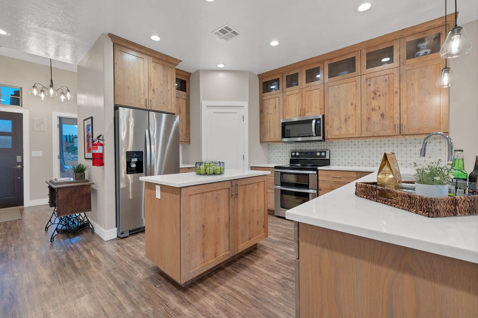 The upstairs kitchen has a four-burner range, refrigerator, dishwasher and microwave. The kitchen is stocked with many small appliances, dishes and utensils.