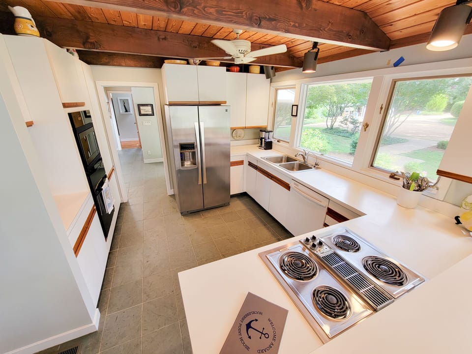 Well appointed gourmet kitchen with artisan cookware, serving pieces, & views