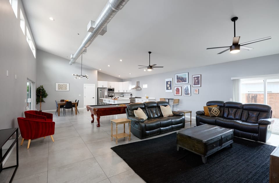 Bright open floor living area, cozy furnishings, smart TV, pool table, additional lounge area, and breakfast table for 2.