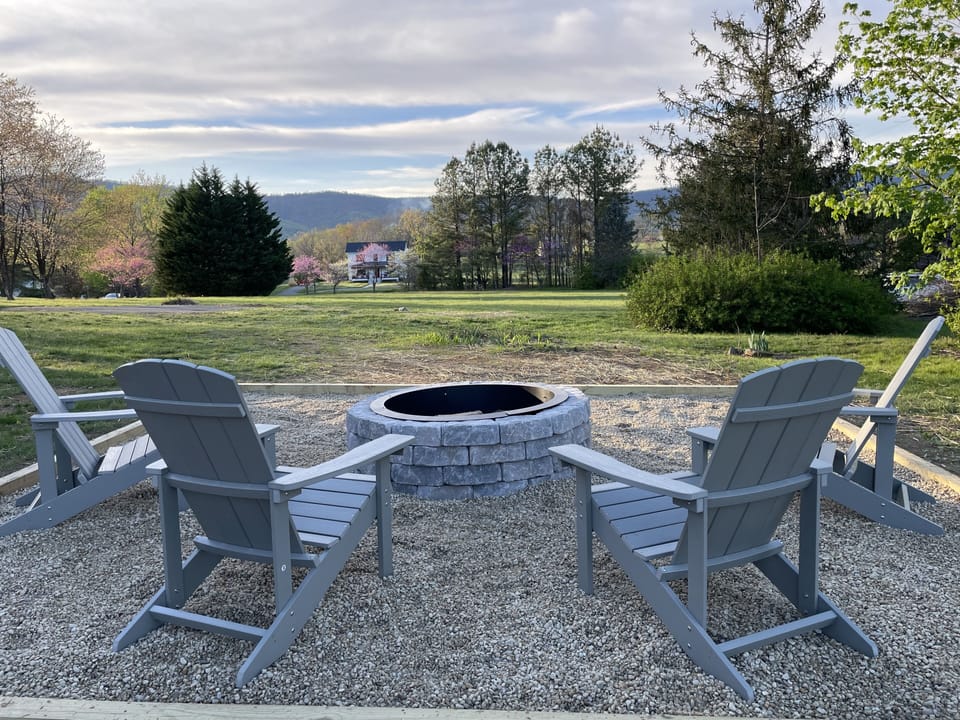 Stone fire pit with adirondack chairs. S’mores anyone?