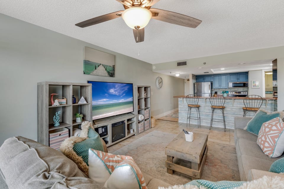 Enjoy the renovated living room featuring a large TV and beach-inspired décor—your perfect spot to unwind after a day by the ocean