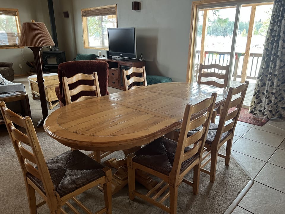 Dining table seats 8 people comfortably, with two armchairs & six armless chairs