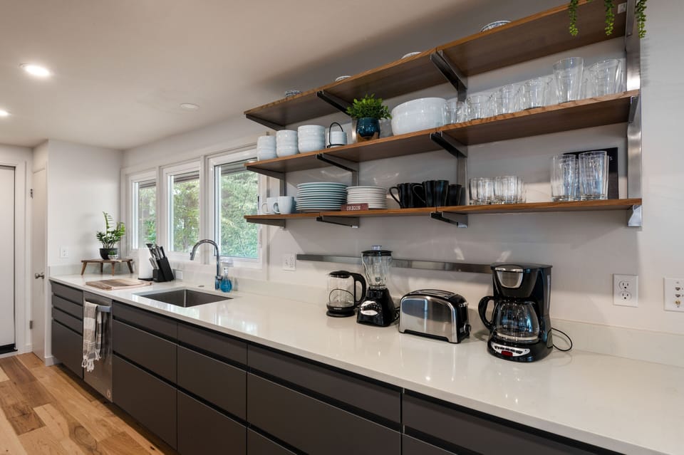 Modern kitchen with open shelves, appliances and dishwasher