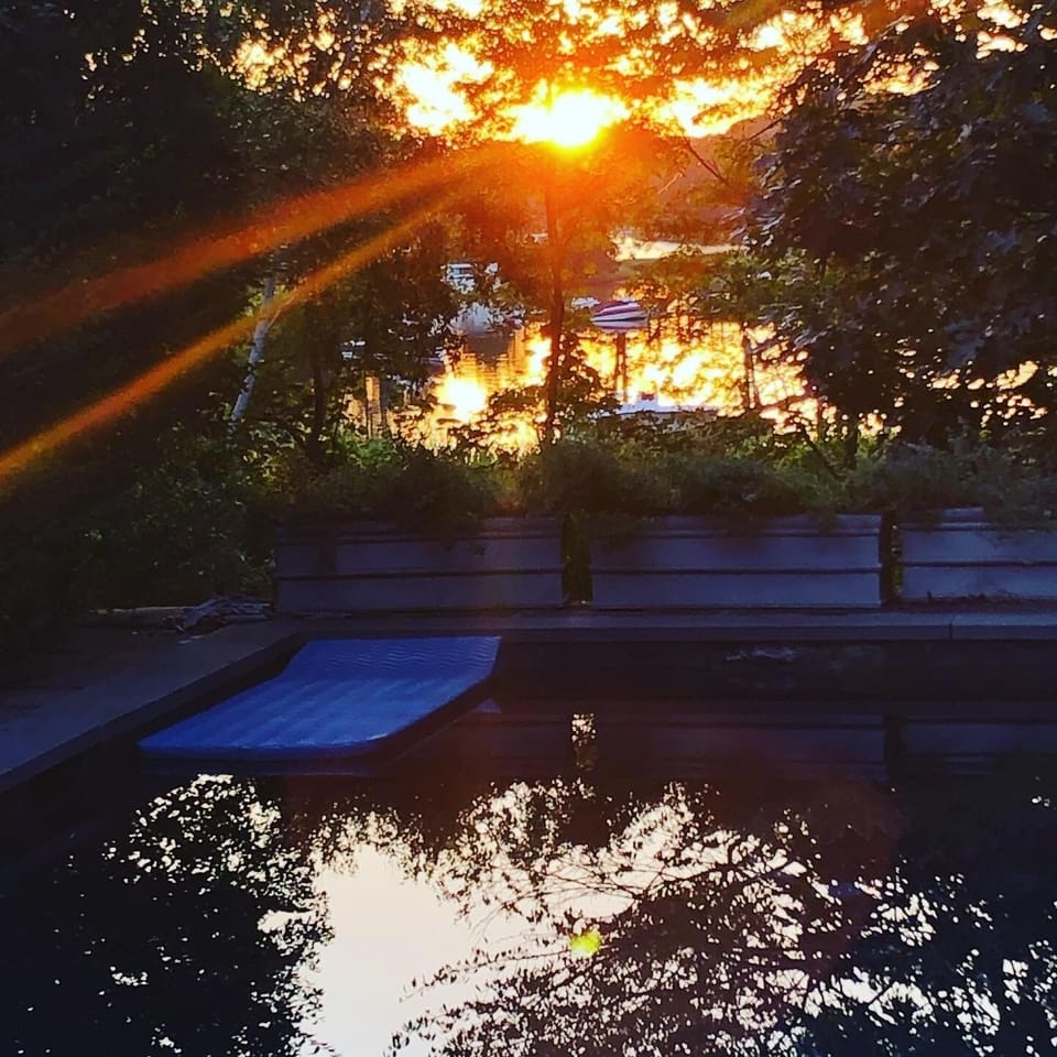 Swimming pool and creek in summer sunset