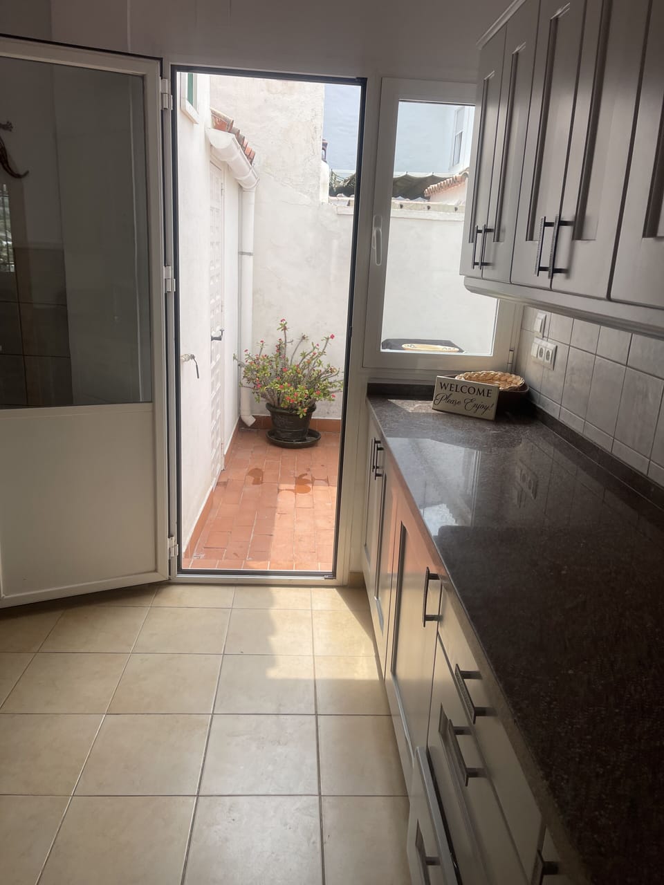 Kitchen leads to back patio and utility rom with a washer and fridge freezer