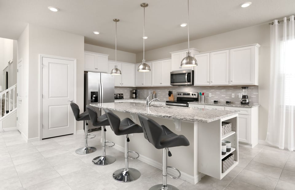 The kitchen has an American-style counter with four leather stools.