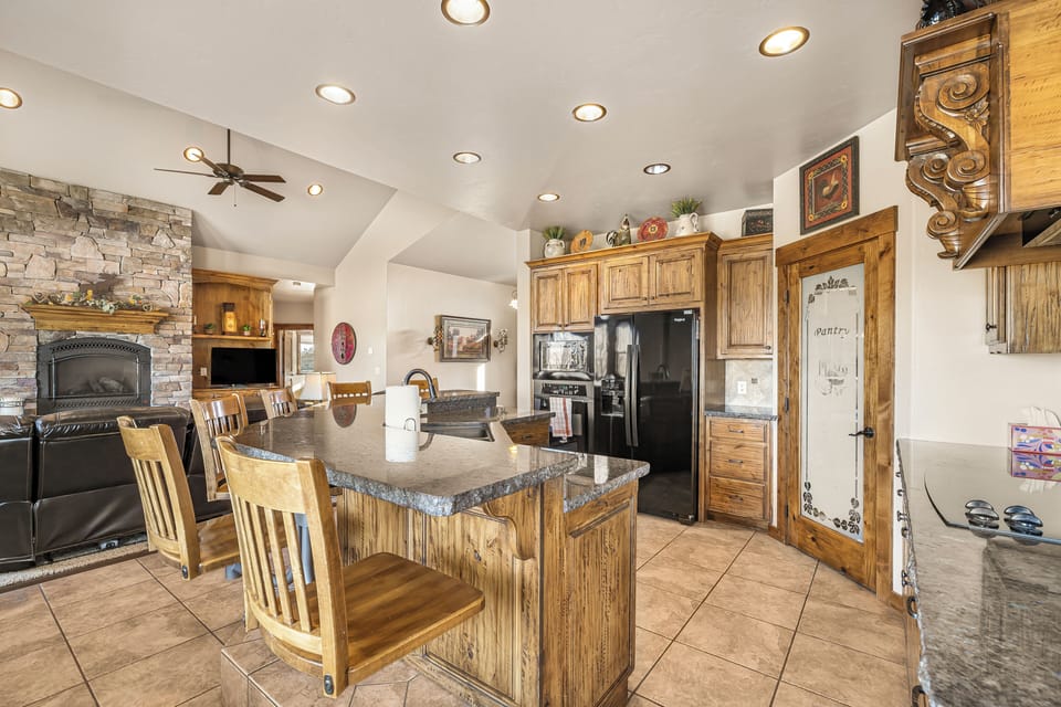 Sideview of kitchen with bar seating, family room and fireplace 
