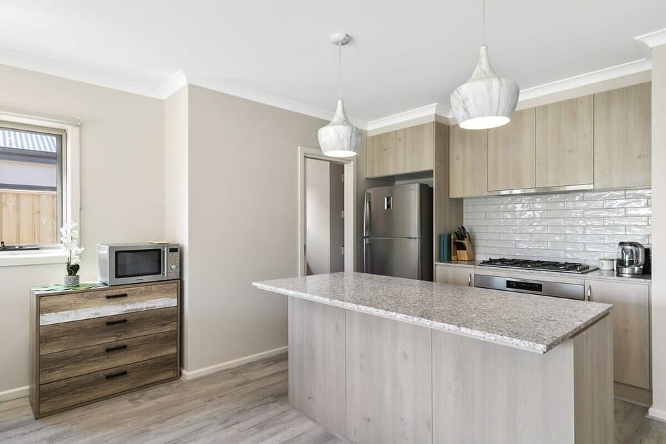 The modern kitchen features an island bench, quality appliances, and a butler's pantry