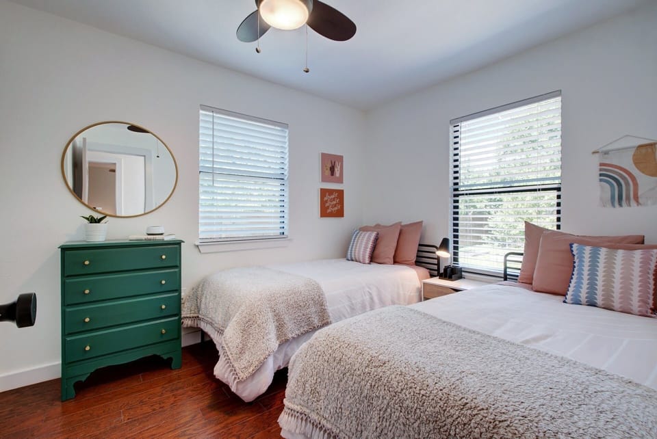 Second bedroom features abundant sunlight, two comfy twin beds and ample storage