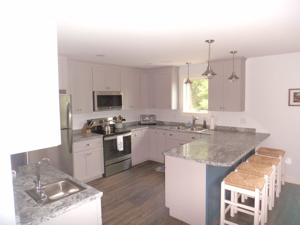 Full size kitchen well equipped with cooking utensils, dishes and glass ware.