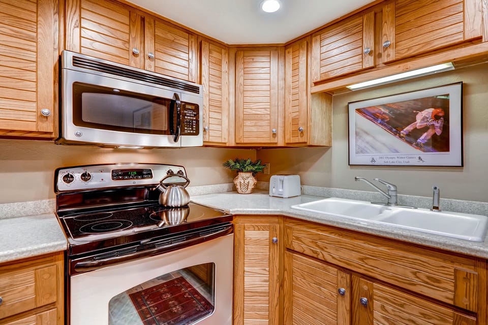 The well-equipped kitchen offers stainless steel appliances and wood cabinets.