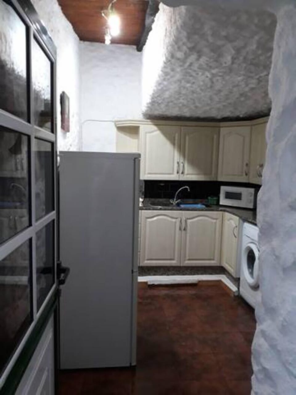Rustic ceiling gives a quirky feel to the kitchen. Full size fridge/freezer here