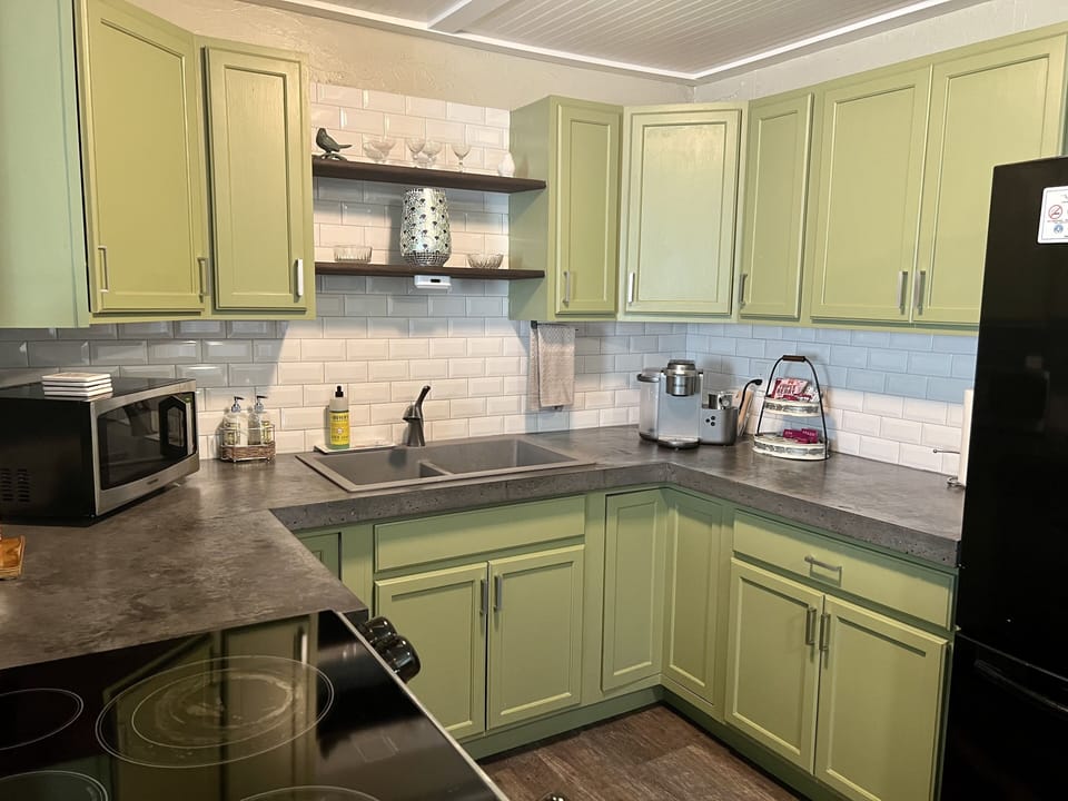 fully furnished kitchen. Actual cupboard color and concrete countertops.