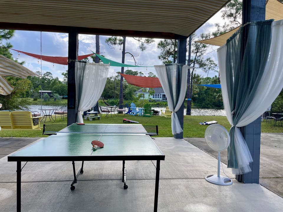 A large entertaining space with ping pong table, fire pit and view of the lake