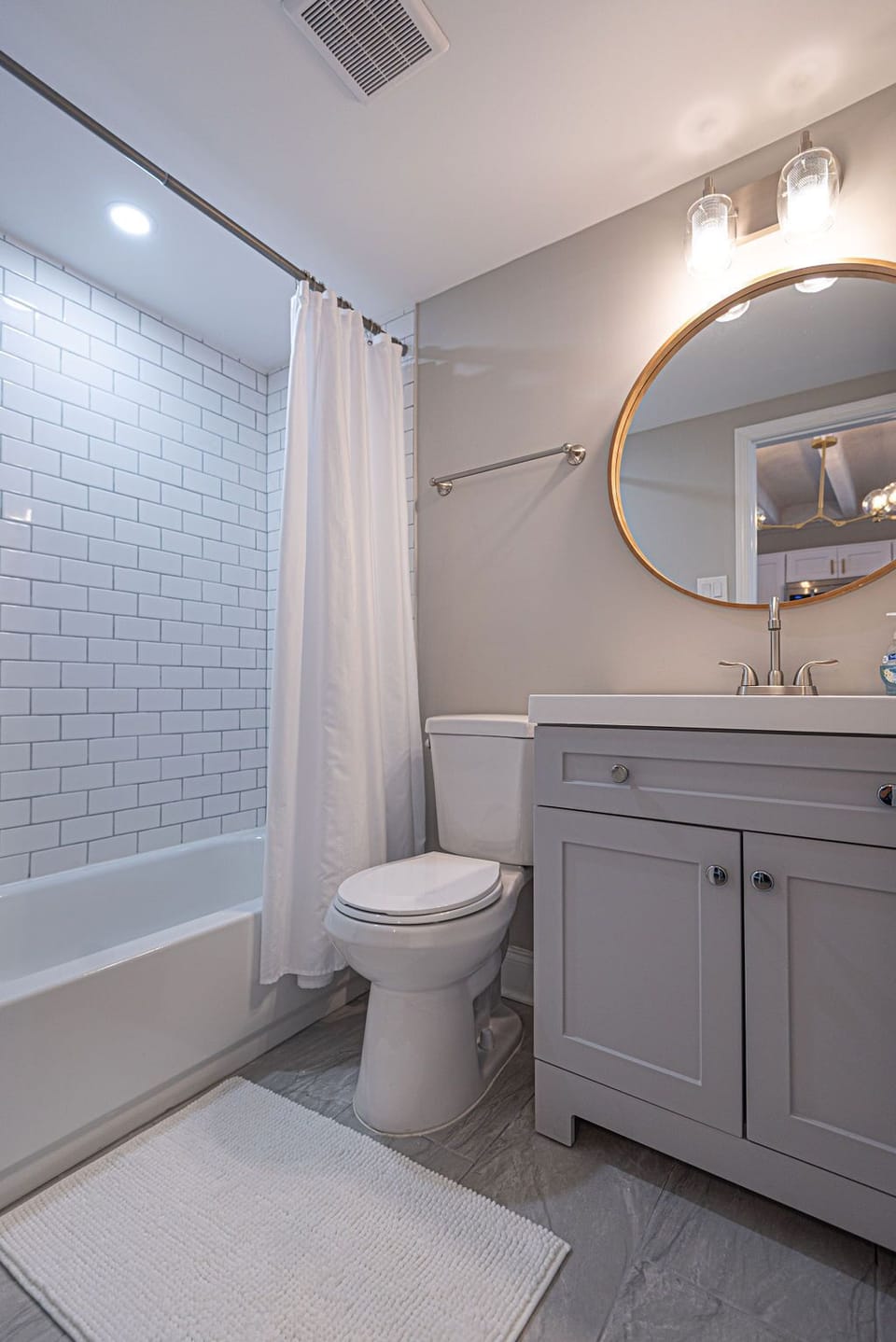 Common full bathroom next to twin bedroom with bathtub.