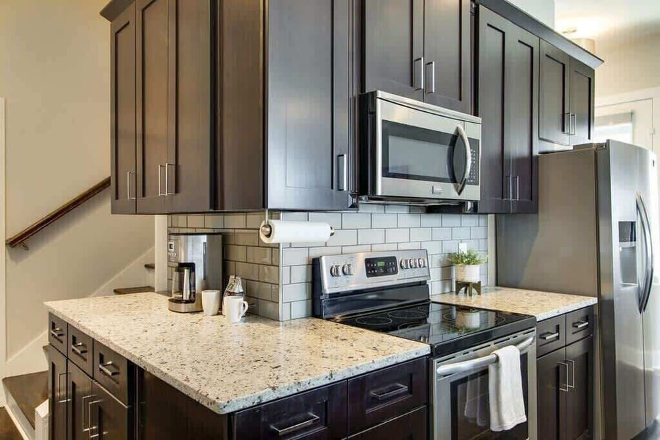 Cook, dine, and relax in a kitchen with brown cabinetry and stainless appliances.