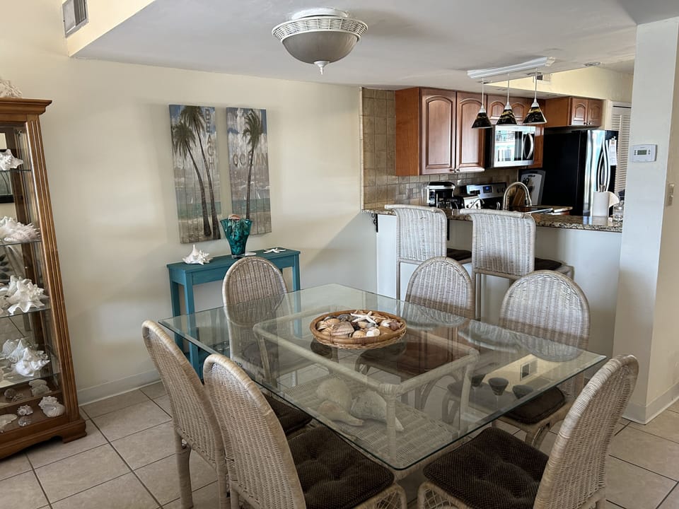 Dining area looking towards kitchen and bar counter with additional chairs