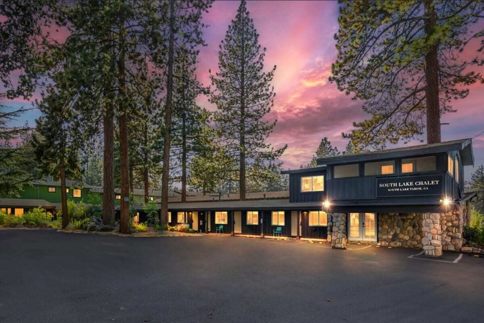 Twilight view of a South Lake Chalet nestled among towering pines