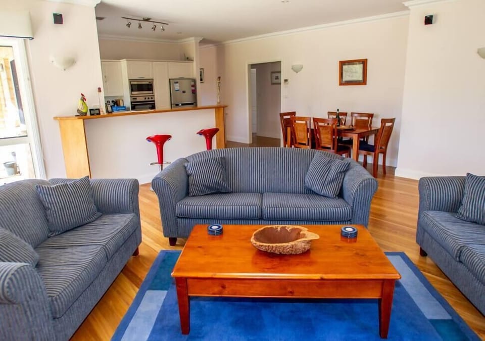 Unwind in our spacious living room with 3 plush sofas and a convenient table.