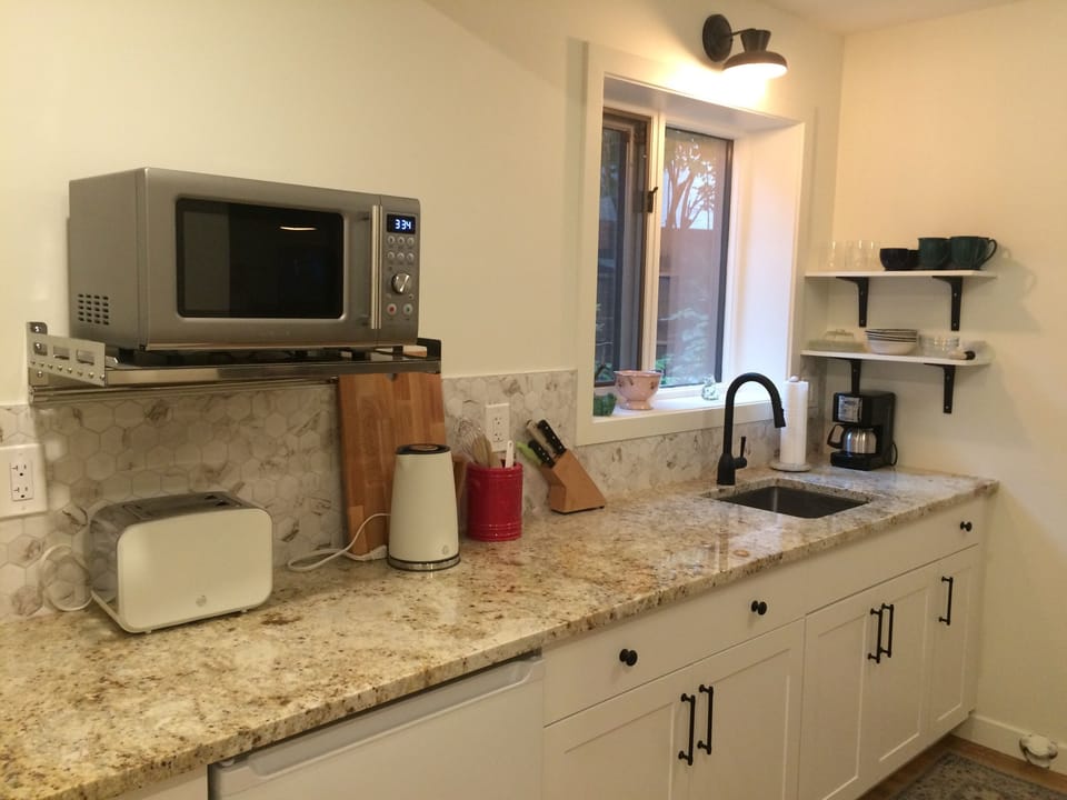 Kitchenette includes fridge, toaster, induction hot plate, and coffee maker.