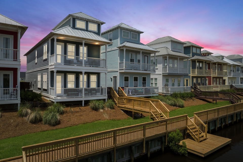 Back view with boardwalk to the pool and small boat dock.