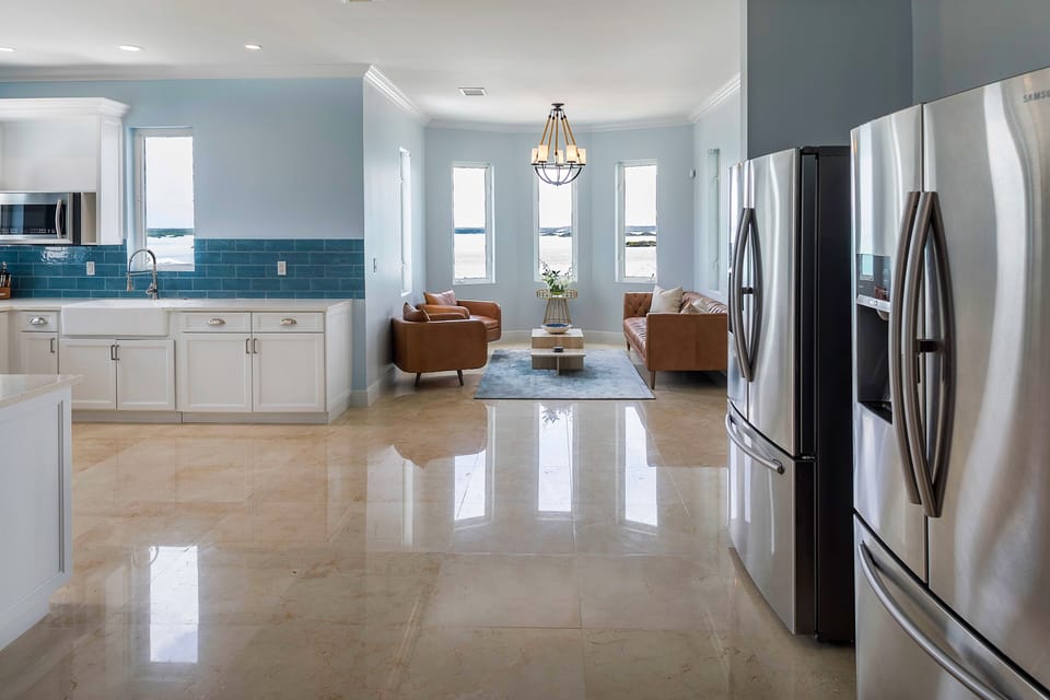 Lower-level view of sitting area, two oversized refrigerators and kitchen space