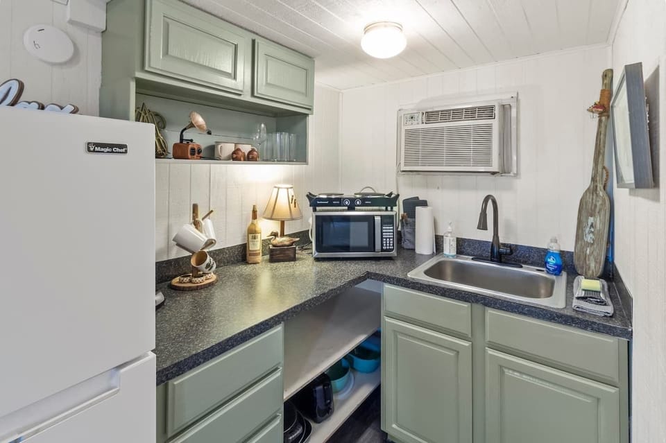 Full sized refrigerator with microwave, 2 burner cooktop, drip coffee maker, pots, pans, dishes