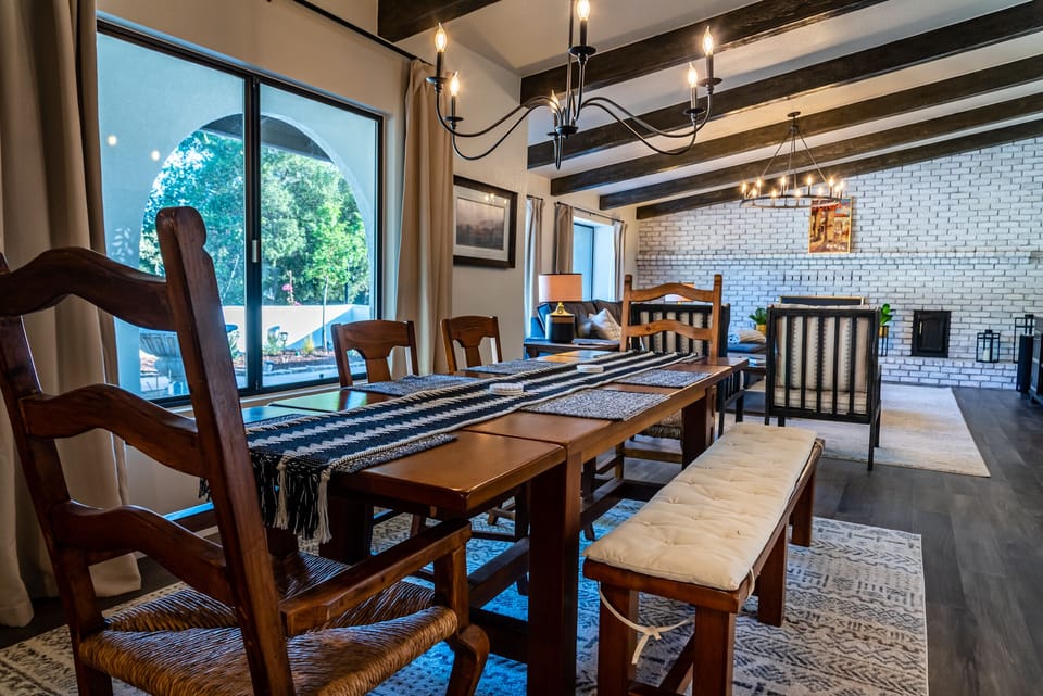 Dining area opening to the kitchen with a sculptural chandelier
