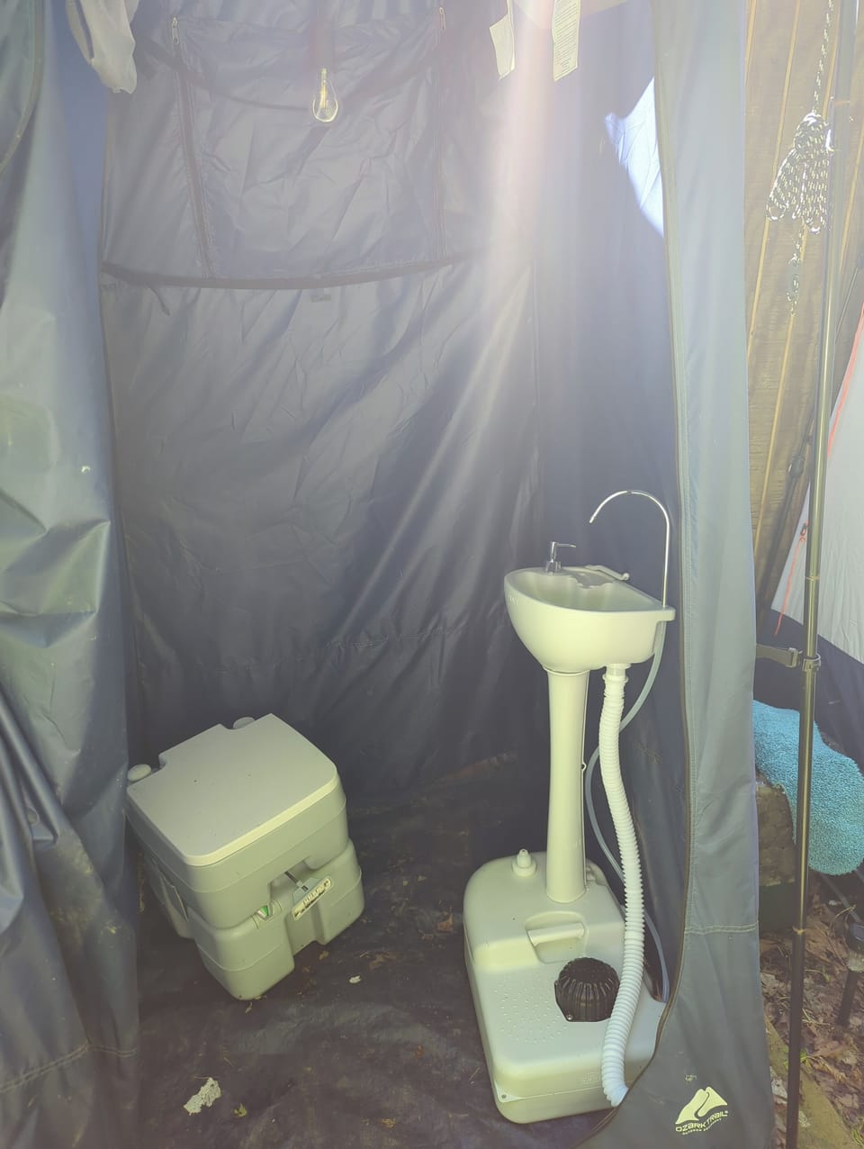 flushable self-contained toilet and sink inside of a privacy tent.