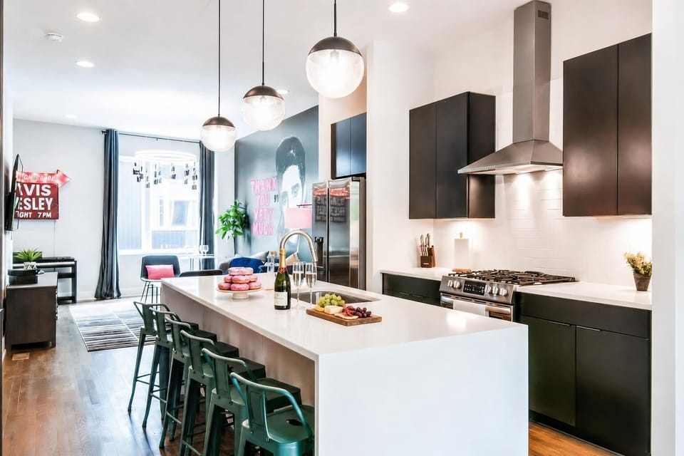 The kitchen island is where everyone gathers at this Nashville house, with bar seating, pendant lights, and sight lines to the living room so the cook stays part of the action