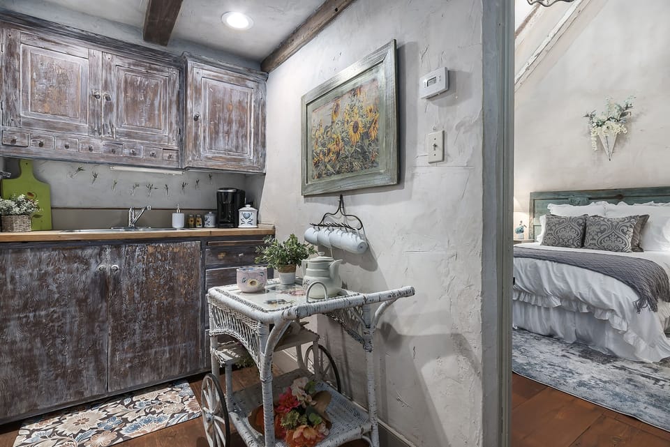 Kitchenette with a mini fridge, microwave, toaster, plates, cups and utensils