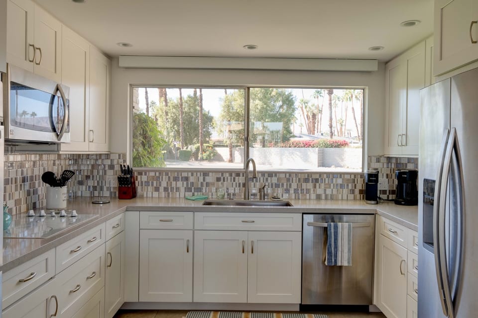 large kitchen area, large farm house stainless steel sink and granite counters