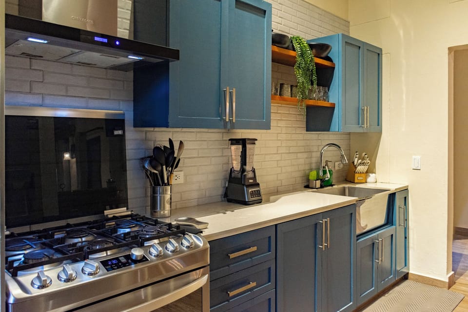 Modern kitchen with blue cabinets and full appliances.