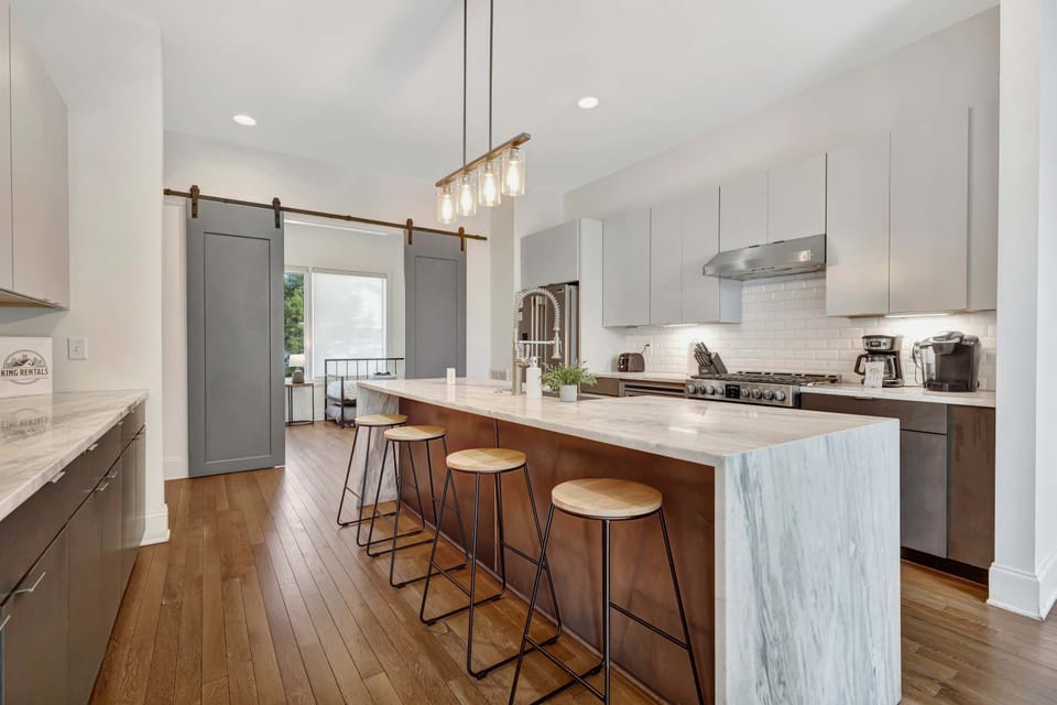Bright, fully equipped kitchen featuring a spacious center island with barstool seating—perfect for cooking and casual dining