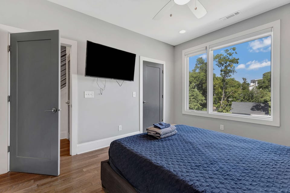 Bright and spacious bedroom with soft touches and window views that add to the cozy atmosphere.
