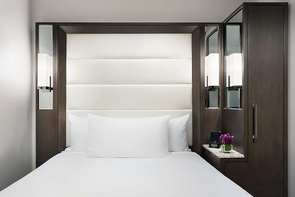 Sink into crisp linens framed by sleek, modern headboard lighting.