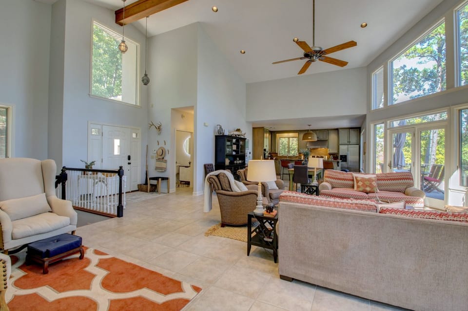 Living room with vaulted ceilings is open to dining and kitchen and hall bath.