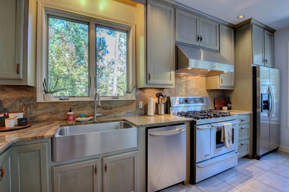 Large chefs kitchen has four ovens, five gas burners and a dishwasher.