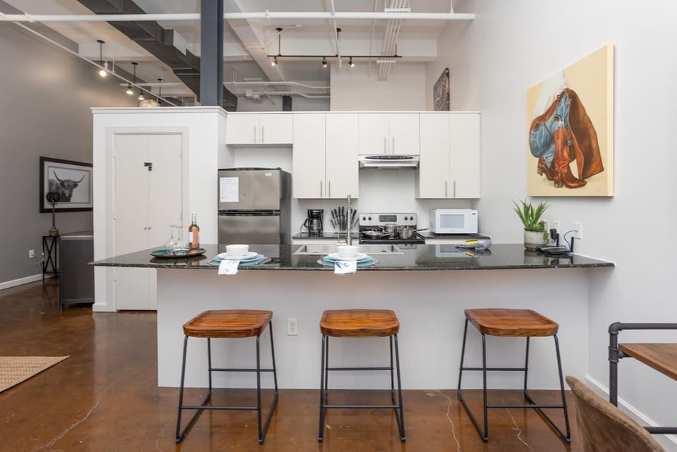 Cook and entertain in a sleek, fully-equipped kitchen featuring modern appliances, ample counter space, and all the essentials for a seamless dining experience in the heart of Fort Worth.