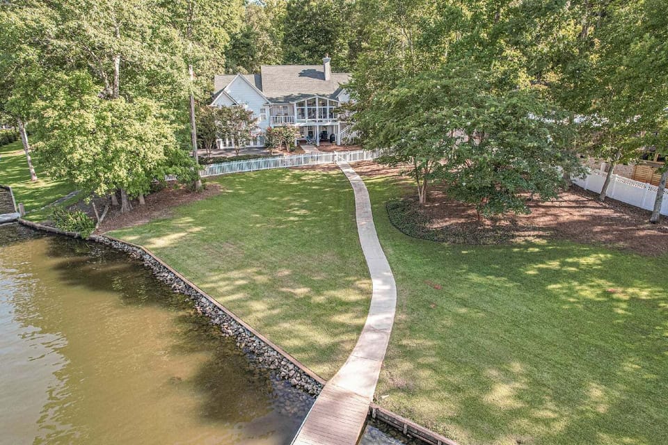 Back of house with paved walkway from house to dock 